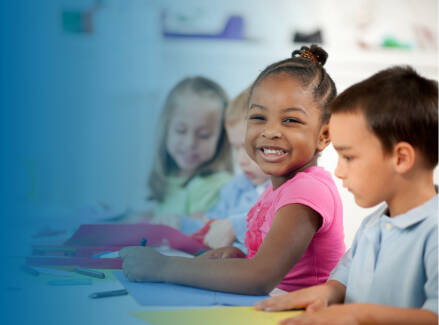 Early childhood students working on a project, smiling